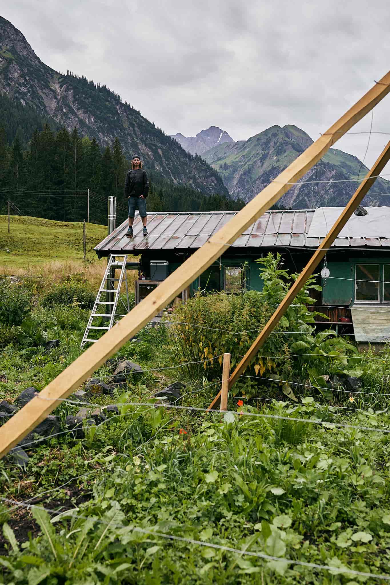 Andi Haller steht auf dem Dach seines Hauses in seinem Permakulturgarten im Kleinwalsertal